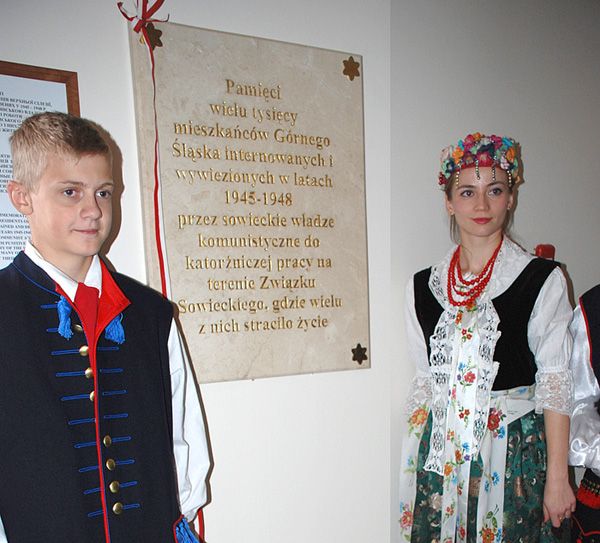 Warta honorowa młodzieży polonijnej przy tablicy w kościele 